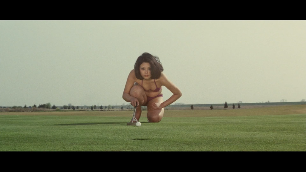 A woman in a bikini plays golf