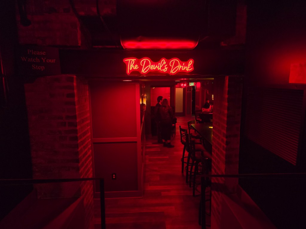 red neon "the devil's drink" sign