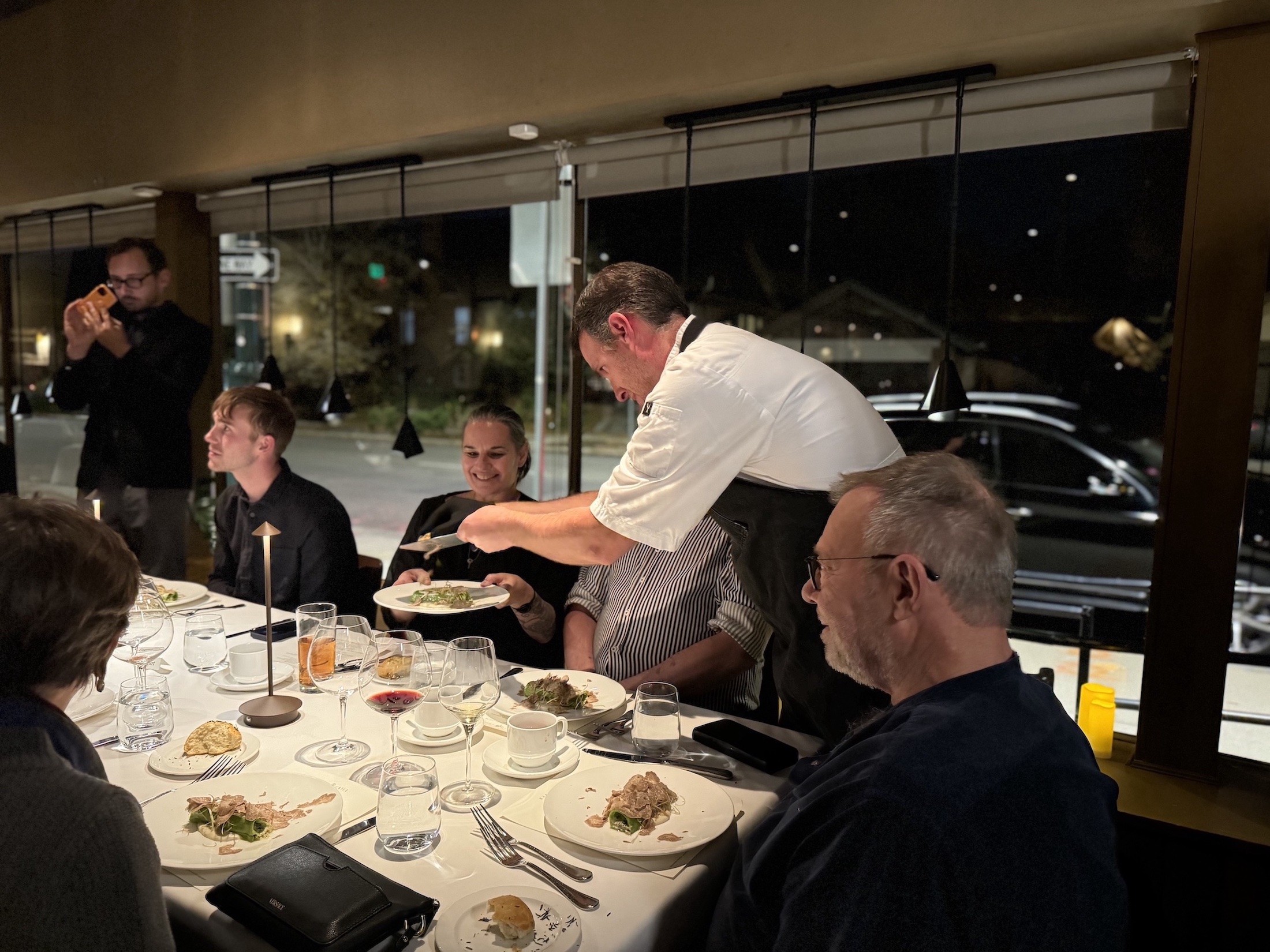 a waiter shaving truffles on a dish