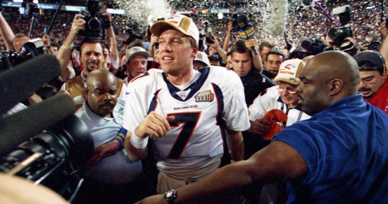 A football player surrounded by media and fans