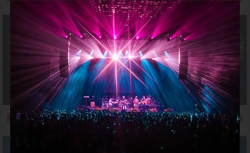 a band performing on stage with pink and blue lights
