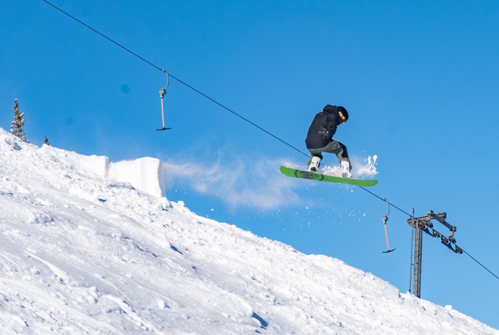 A snowboarder in the air while performing a trick at Breckenridge Ski Resort