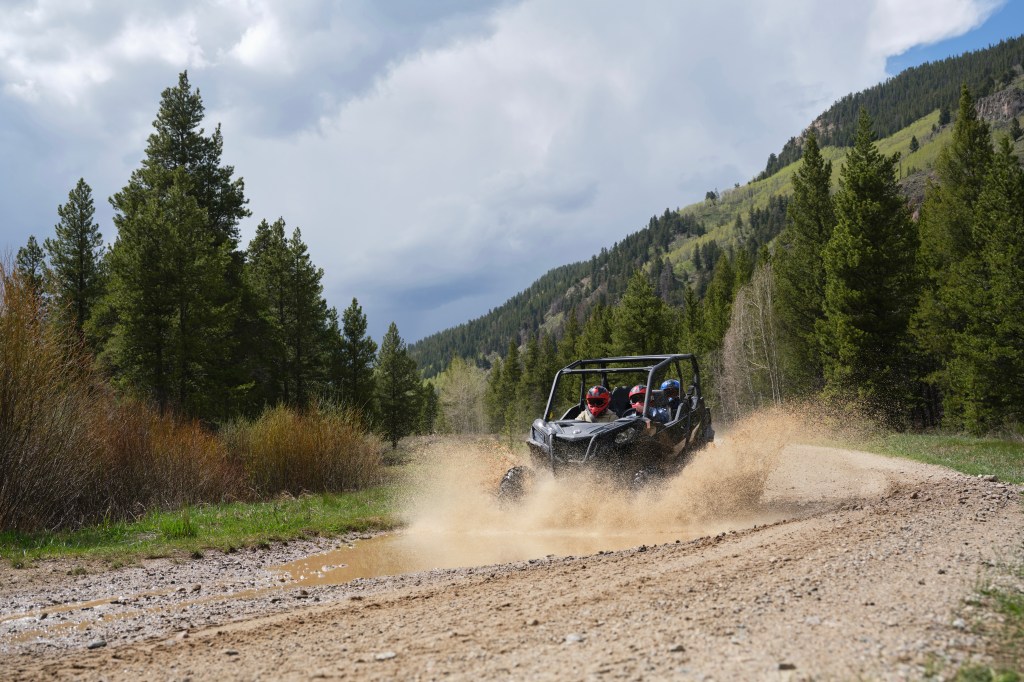 An ATV splashing through a wet dirt road at Camp Hale-Continental Divide National Monument