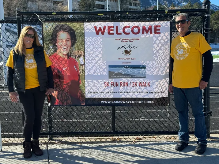 People stand around a fence