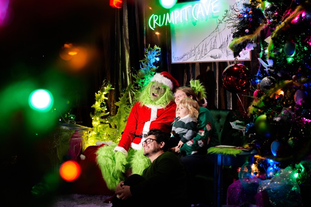 A family posed for a photo with the Grinch at Free Market within Dairy Block