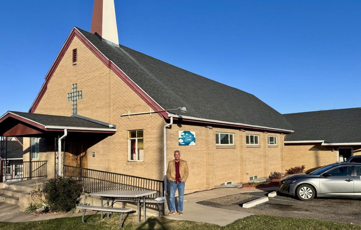 pastor stands in front of his church