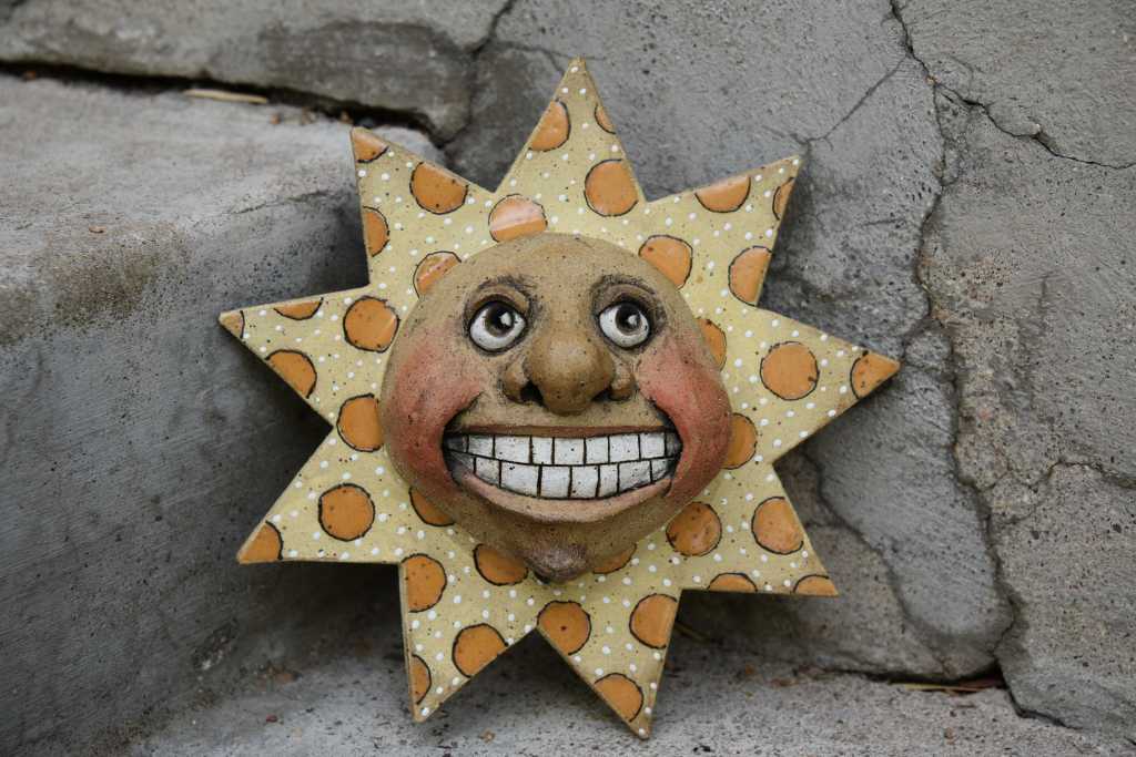 A ceramic sun with a smiling face