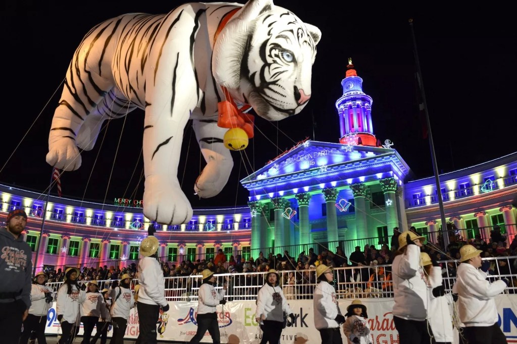 A giant white tiger balloon floating past Denver City Council during the Parade of Lights