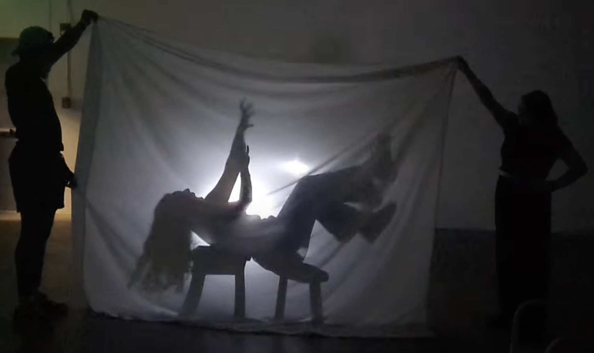 A theatrical shadow effect frames a person reaching up to the sky.