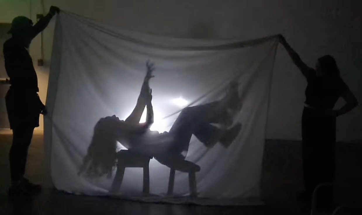 A theatrical shadow effect frames a person reaching up to the sky.