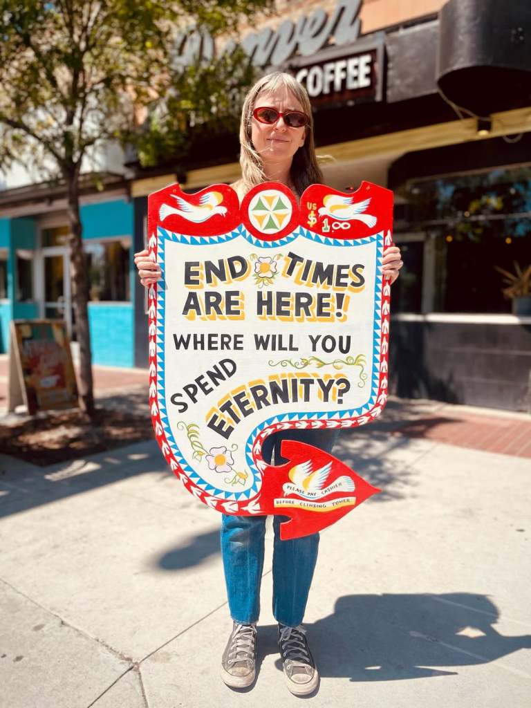 Jae Mo holding a sign that reads "END TIMES ARE HERE! WHERE WILL YOU SPEND ETERNITY?