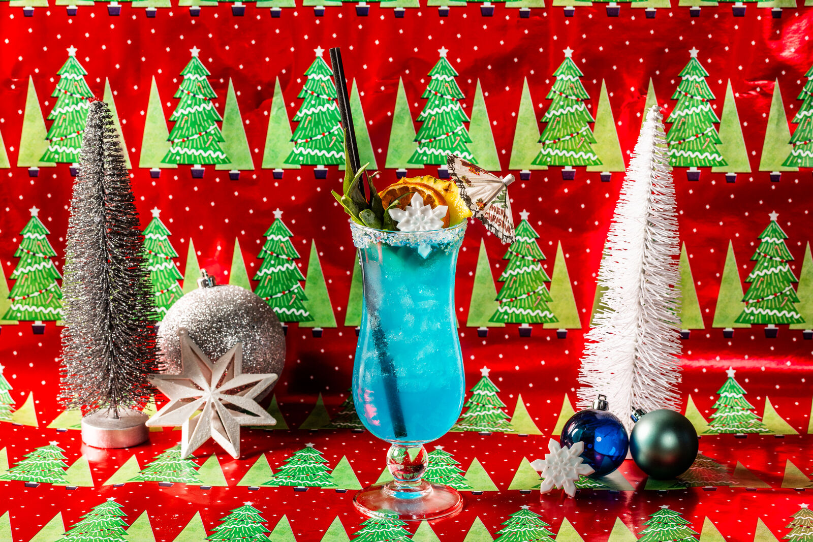 a blue cocktail in front of holiday decor