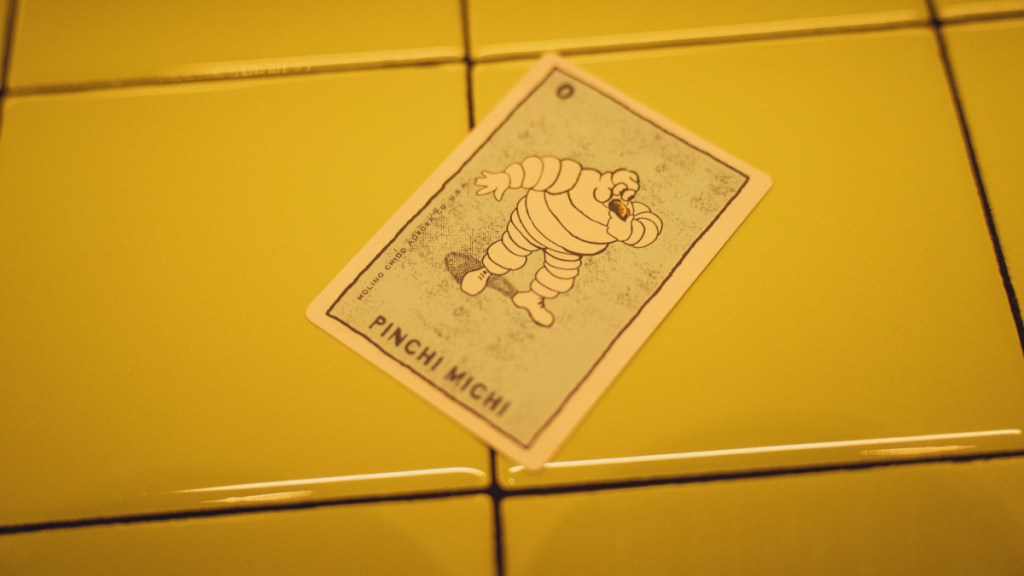 card with Michelin Man mascot eating a taco