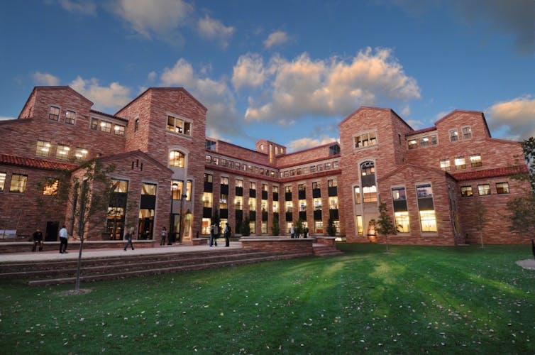 A large brick building with blue skies and clouds in the background.
