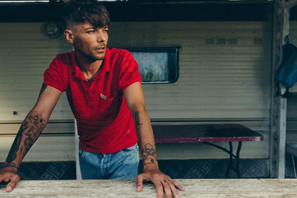 Louis tomlinson in a red polo and jeans