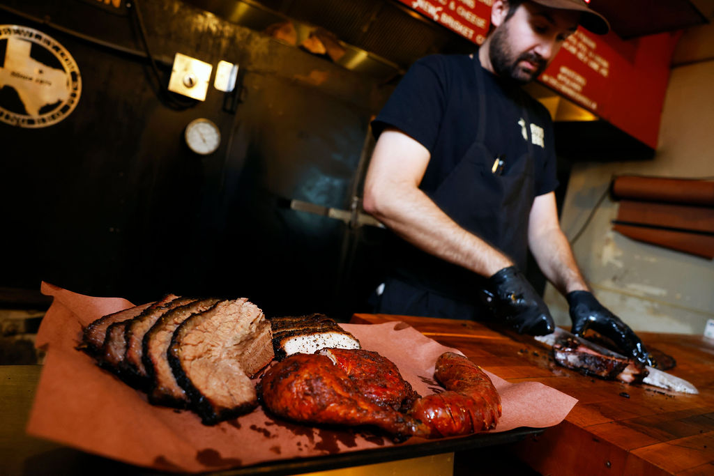 man slicing BBQ meats