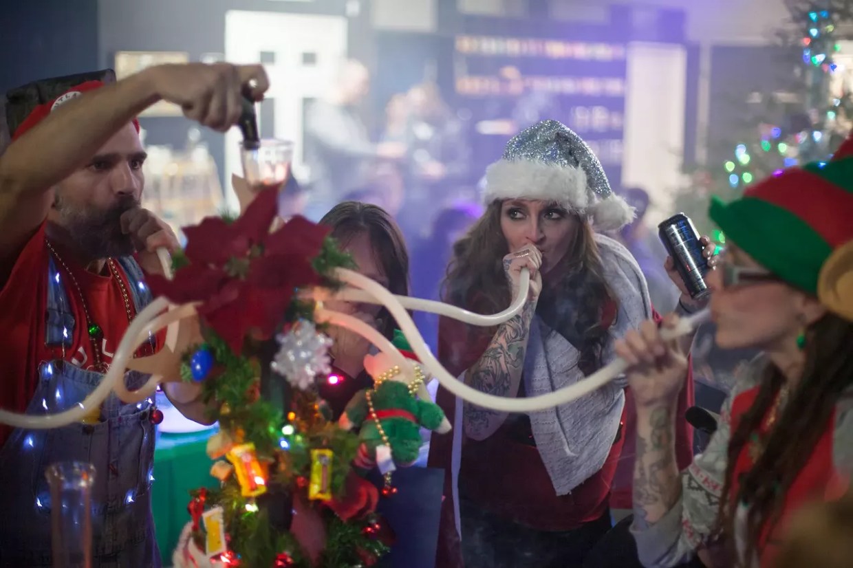 people in christmas costumes smoke weed out of hookah