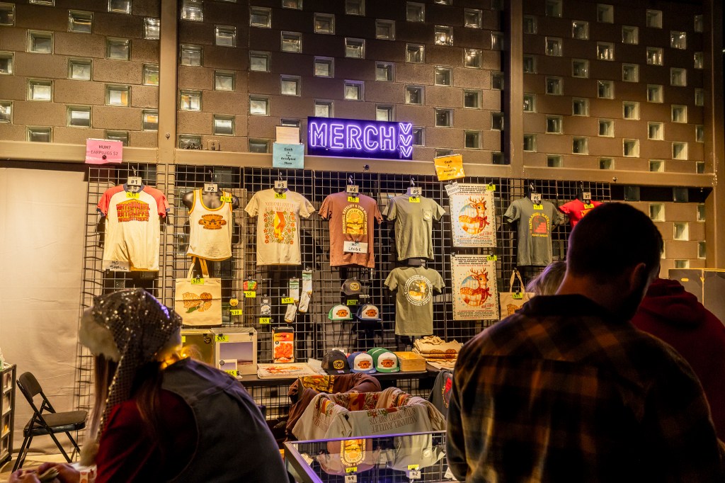 Concertgoers shopping at the merch booth at Mission Ballroom.