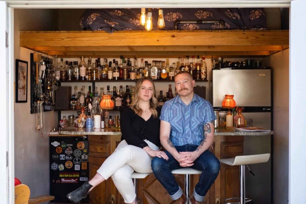 woman and man sitting in front of a bar