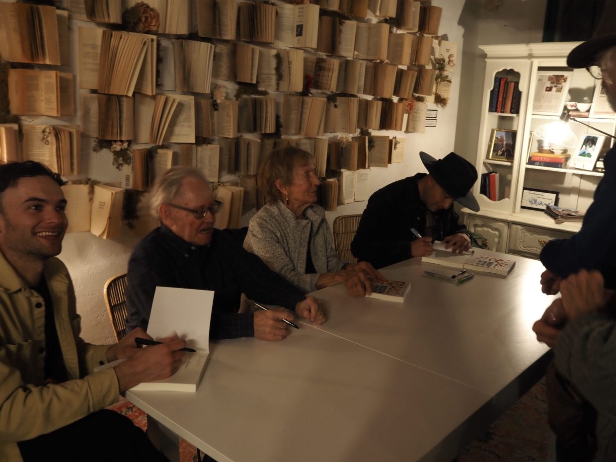 A table of people sign books