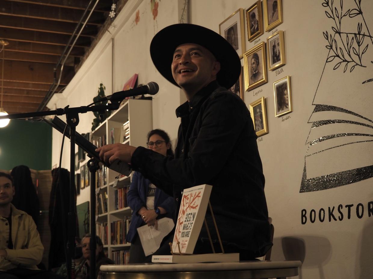 A man smiles at a microphone
