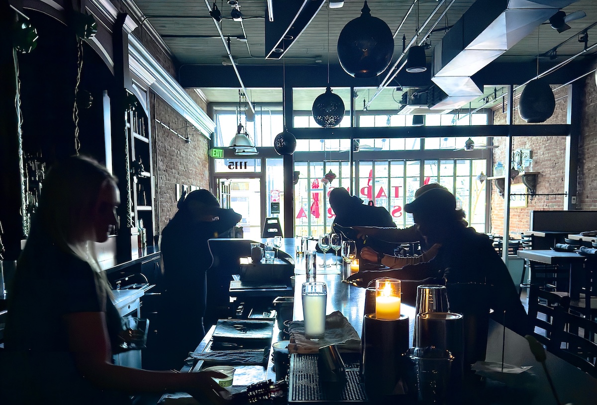 bartenders pour drink in dark bar without electricity
