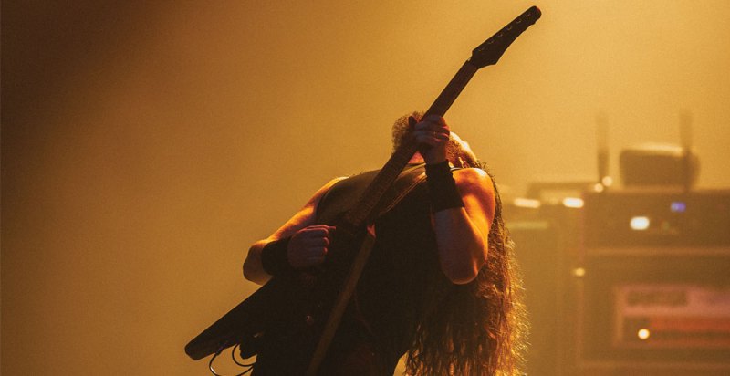 man leaning back while playing guitar