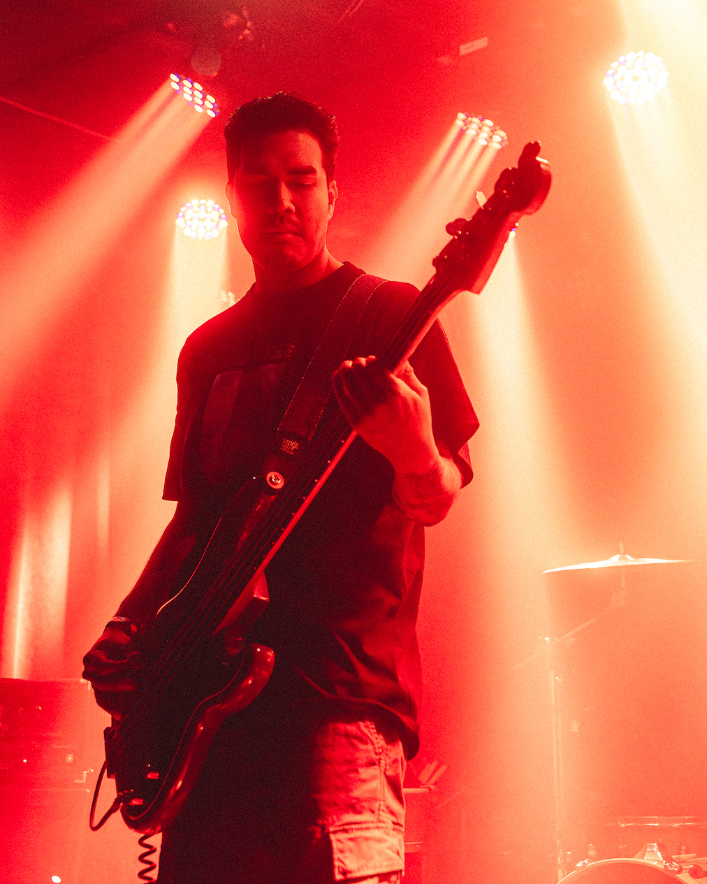 A person playing bass guitar on stage