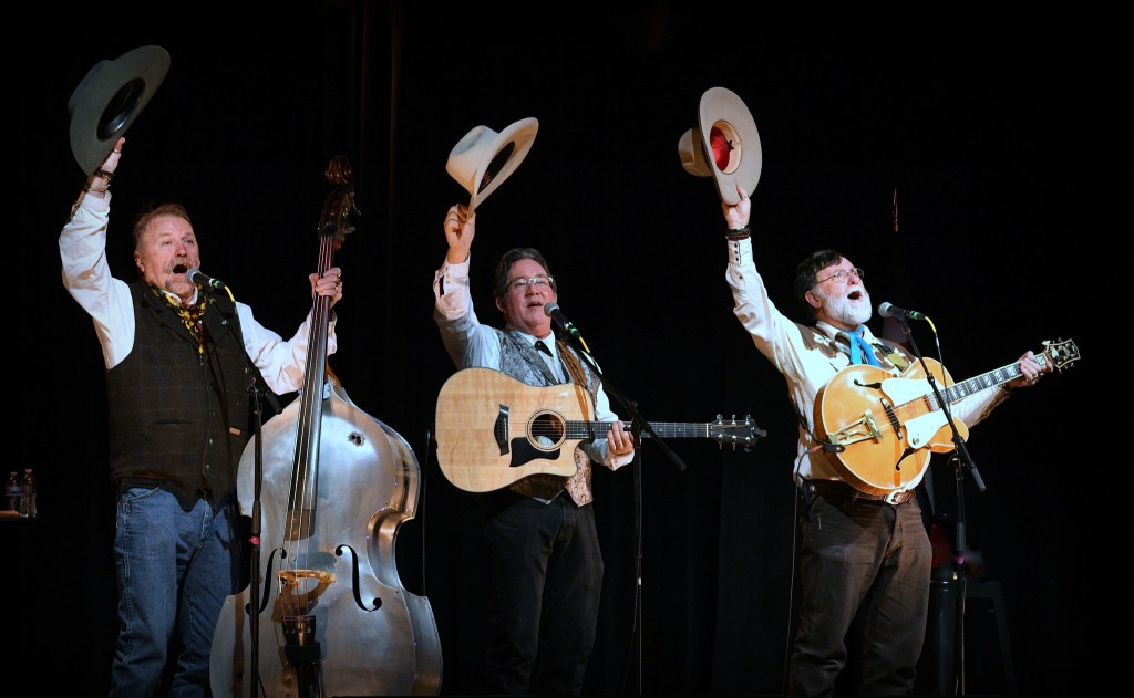 Three cowboys perform