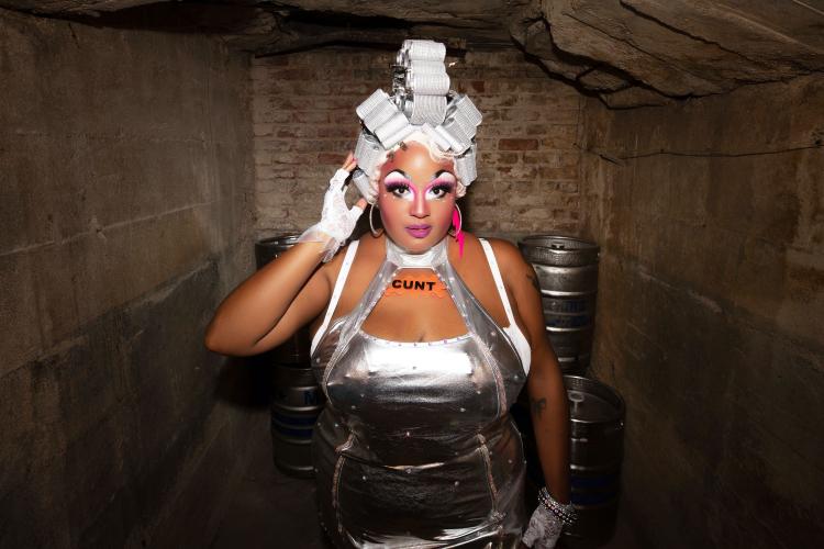 Drag queen Coco Bardot posing in a silver dress.