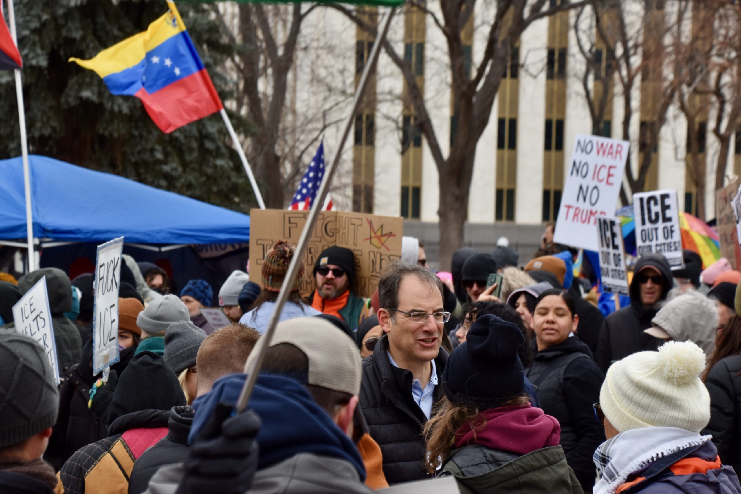 phil weiser with protesters in denver
