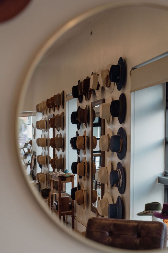 Hat wall reflected in mirror at Gem Hats in Denver.
