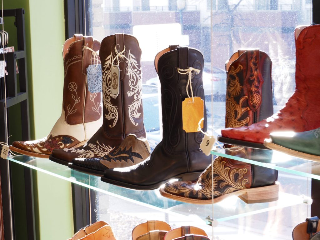 a shelf of cowboy boots