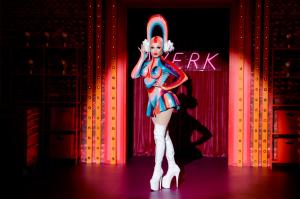 Nini Coco entering the RuPaul's Drag race workroom in a rainbow latex outfit.