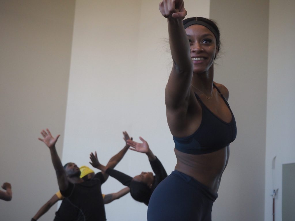 A dancer smiles and points