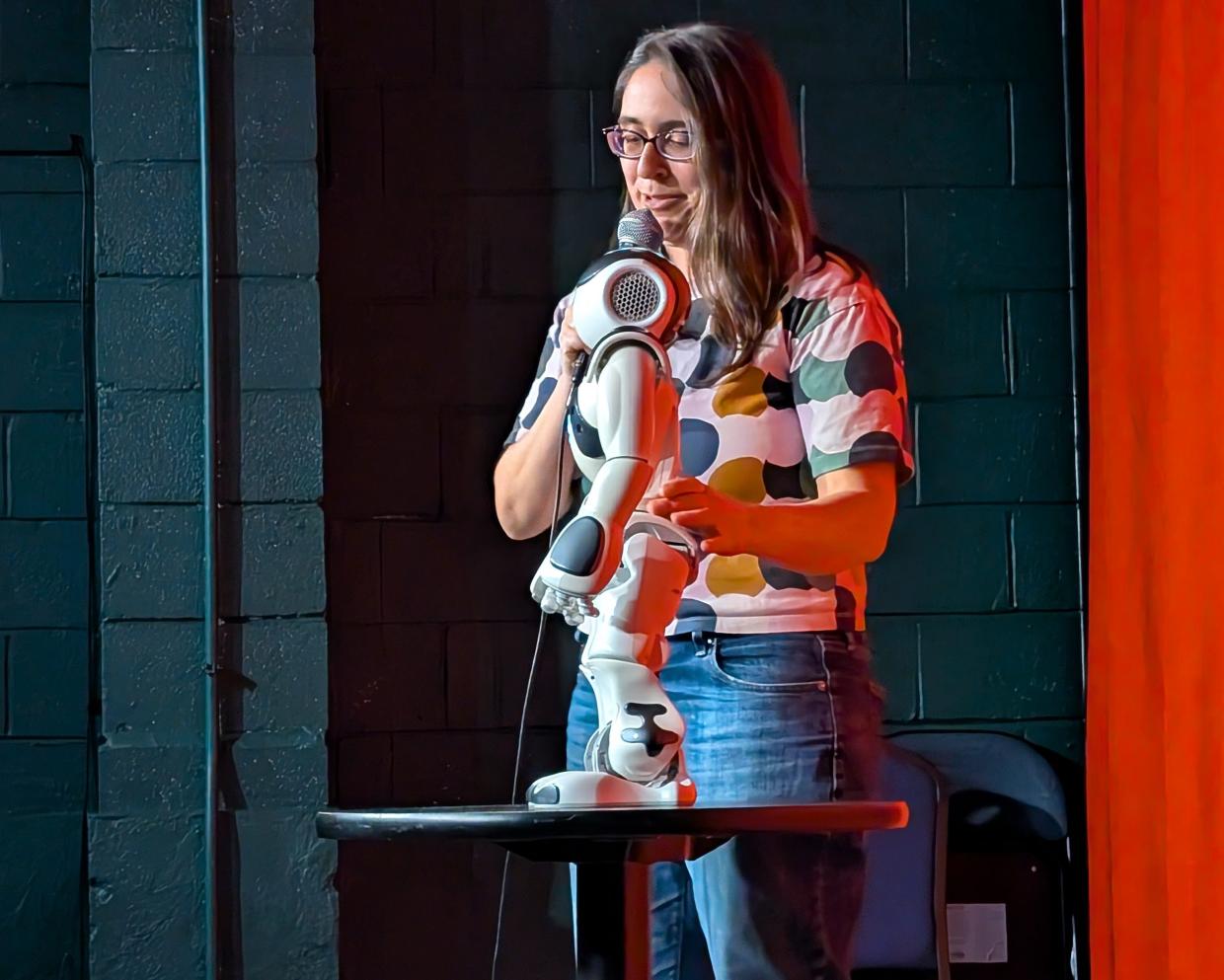 A woman performs onstage with a robot