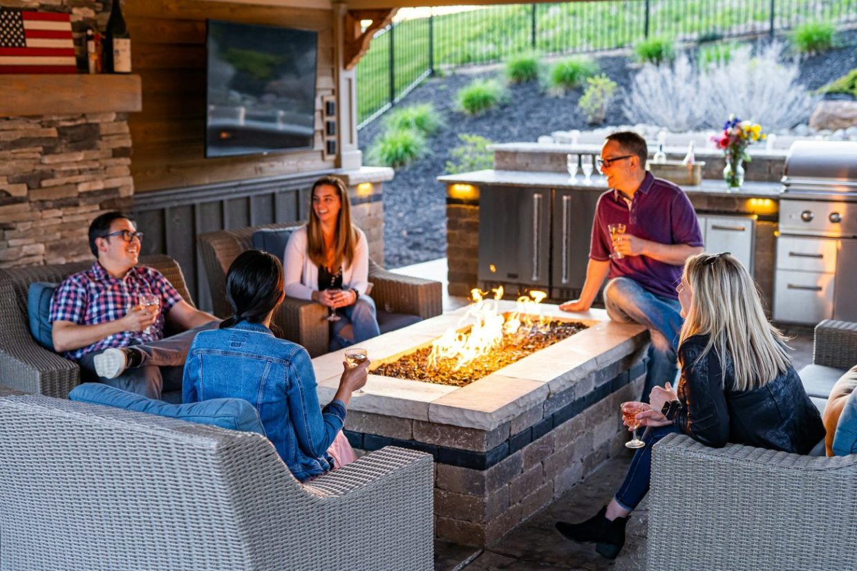 friends hang out in backyard by fire