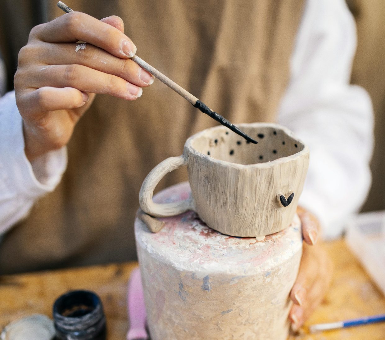 A person painting a mug