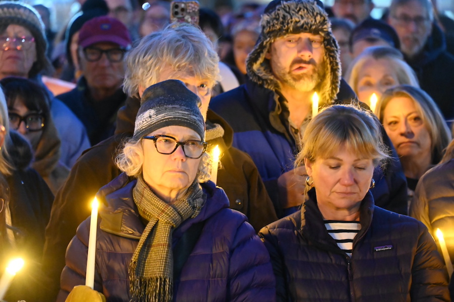 mourners hold candles at vigil