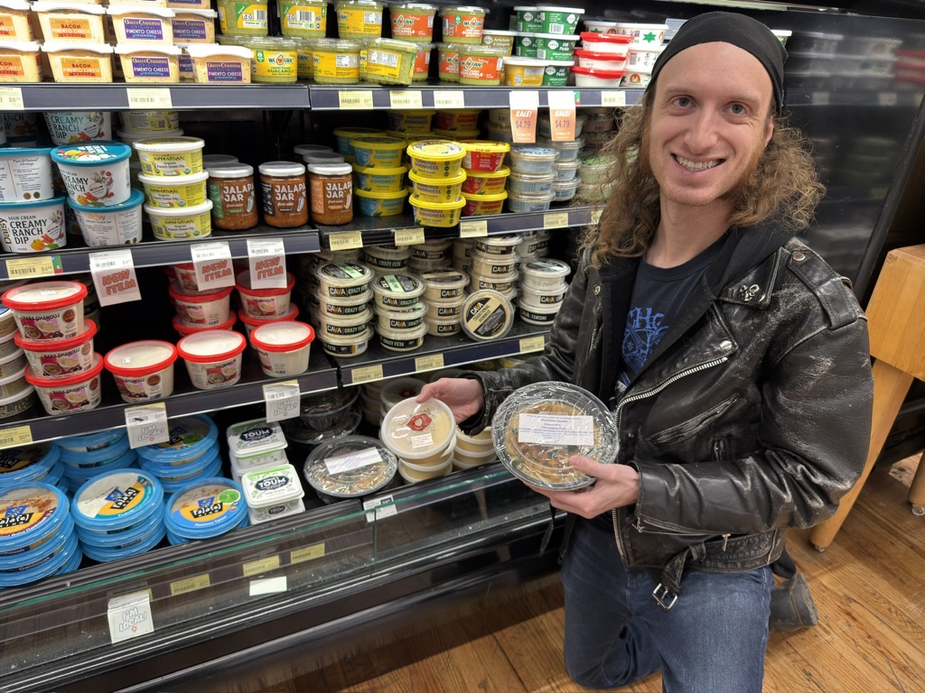 a man stocking hummus