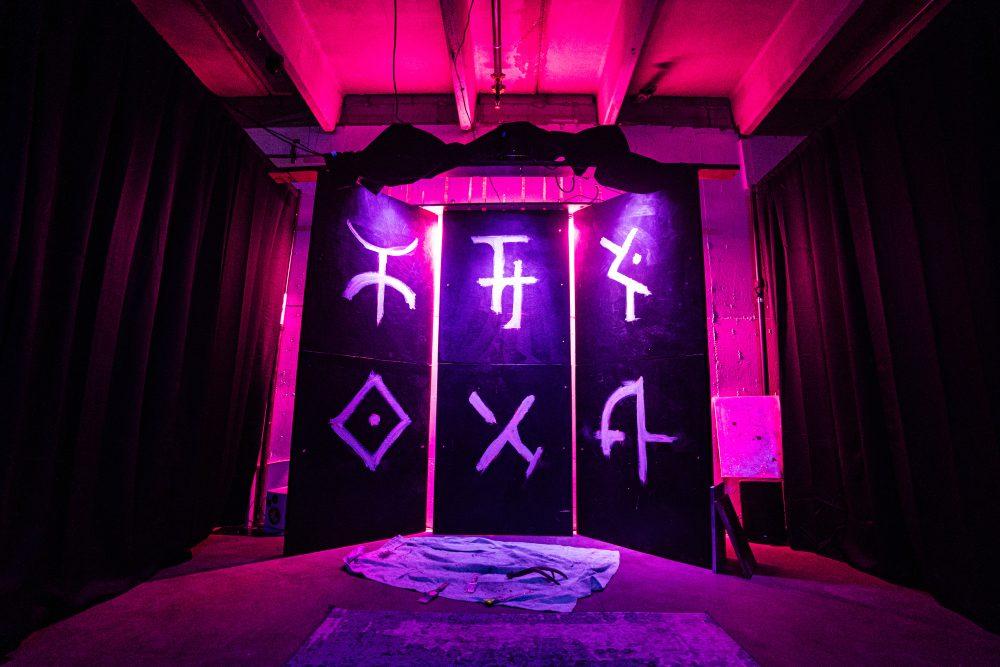 Mysterious symbols on panels in a pink-colored room
