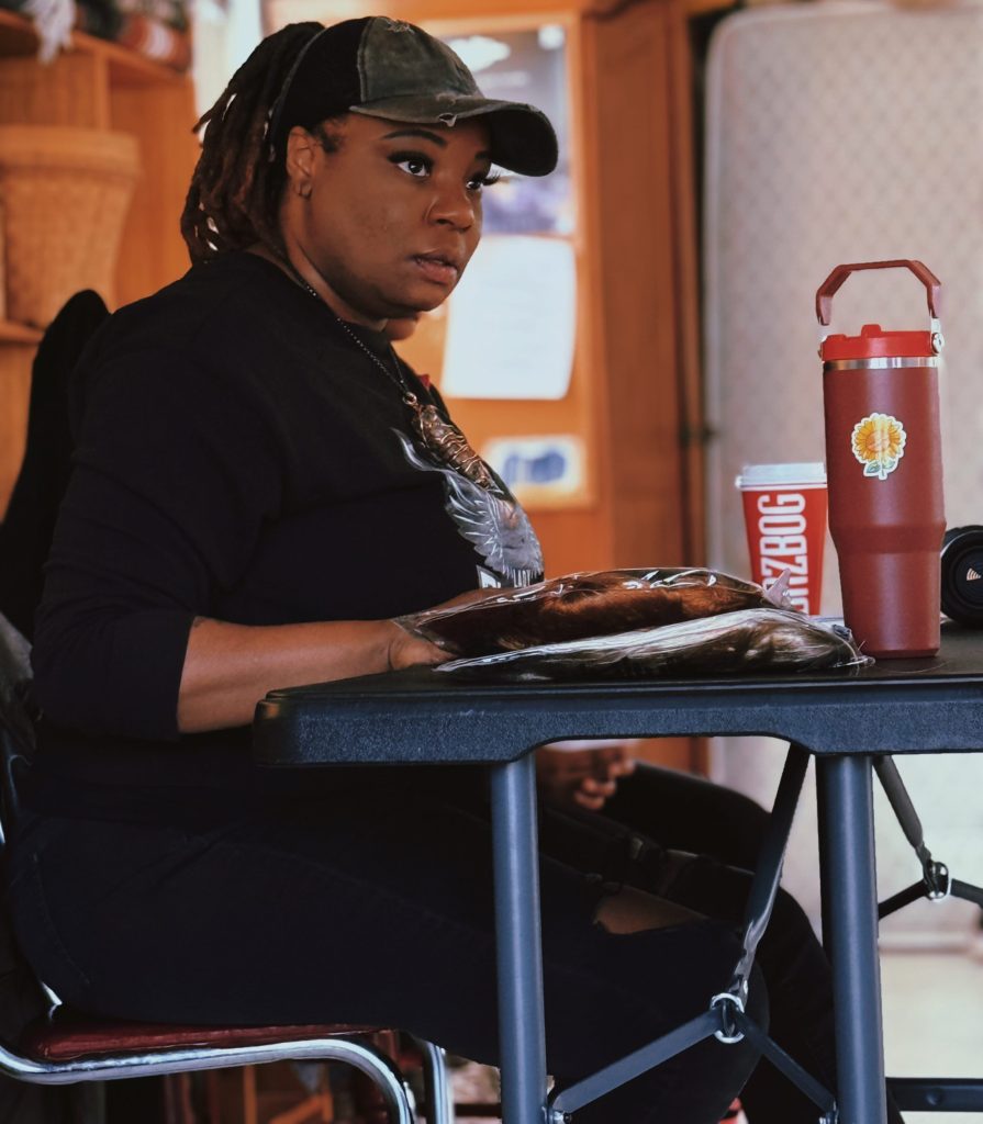 A woman sits behind a table with a script in front of her