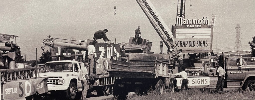 A black and white photo of signs being removed