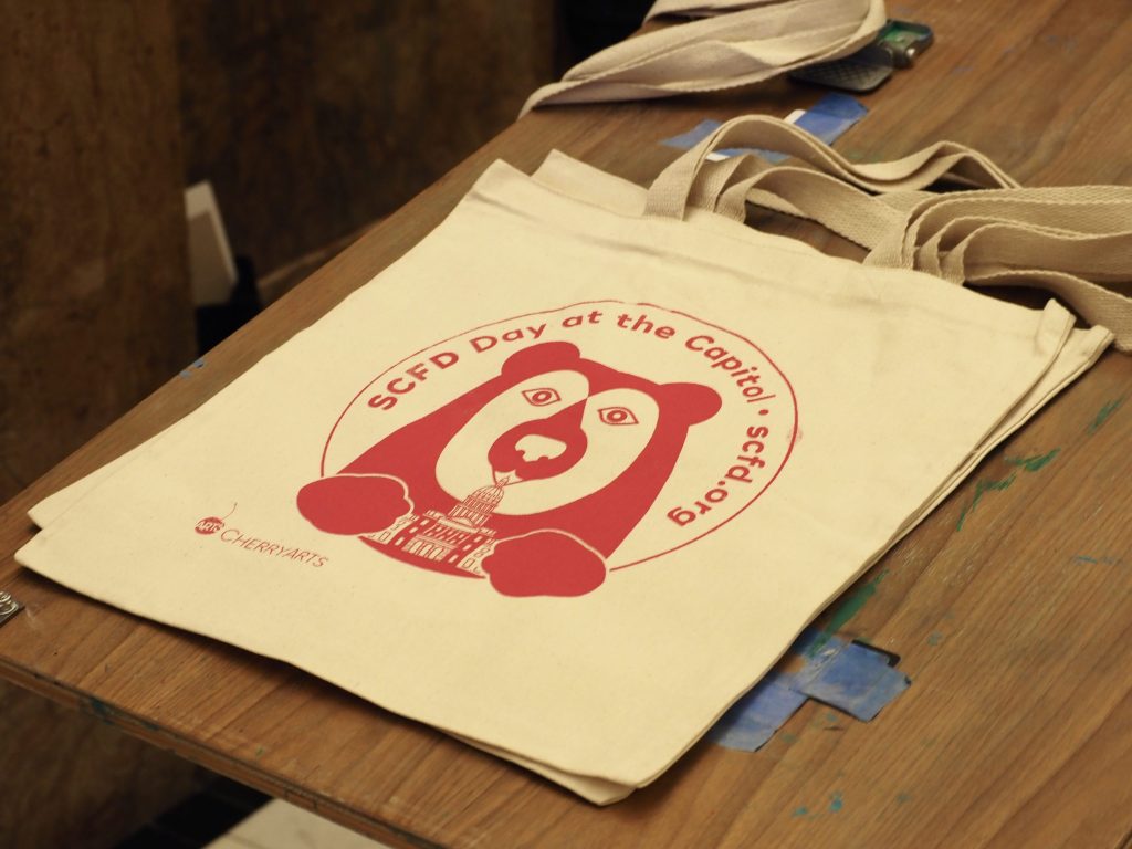 A tote bag with the SCFD logo