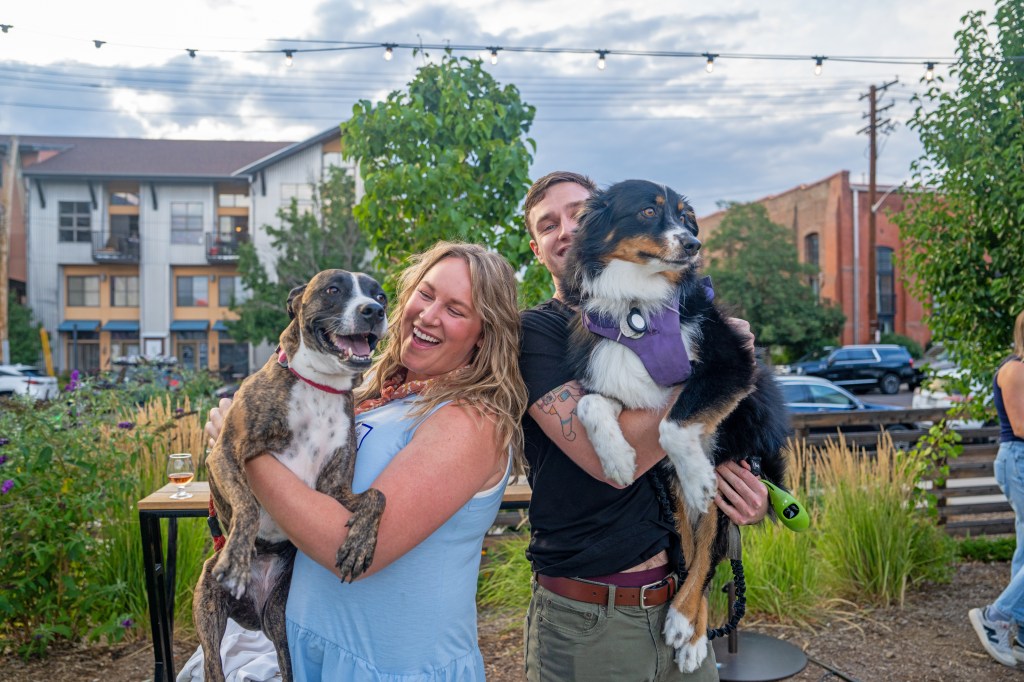 Two people holding dogs