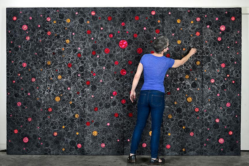 An artist paints colorful circles
