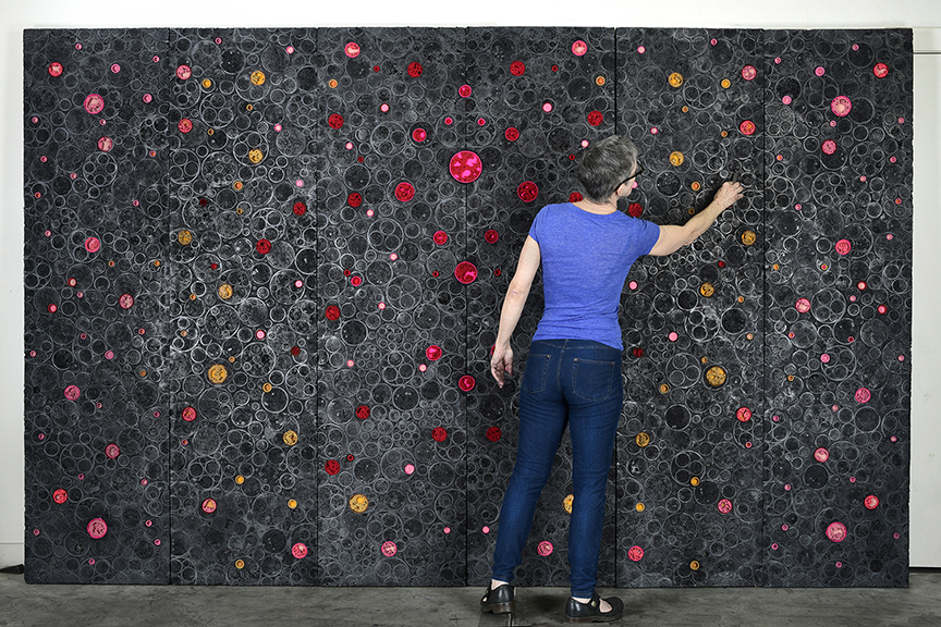 An artist paints colorful circles