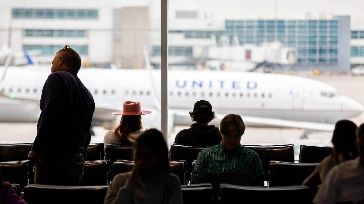 Passengers wait in concourse seating at the Denver International Airport