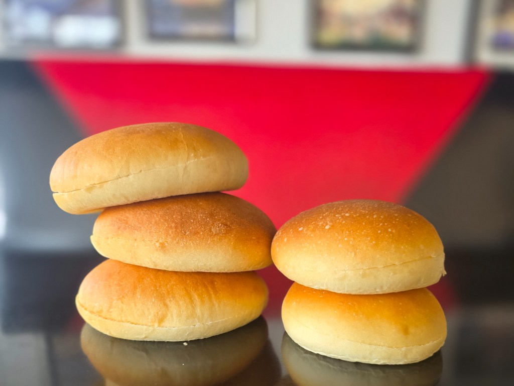 five hamburger buns on a counter
