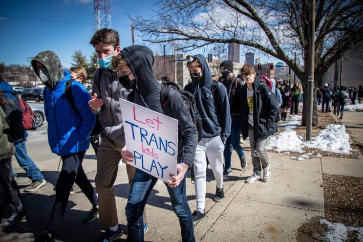 Transgender activists protests with signs on the sidewalk